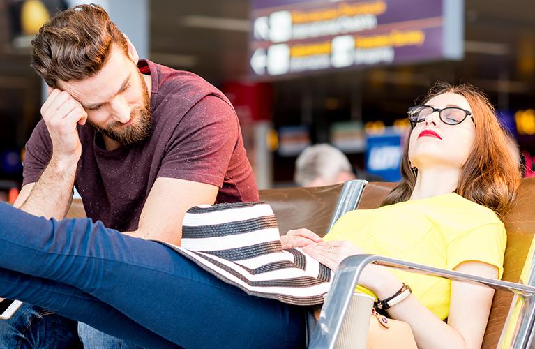 Un couple attend à l’aéroport son vol retardé ou annulé