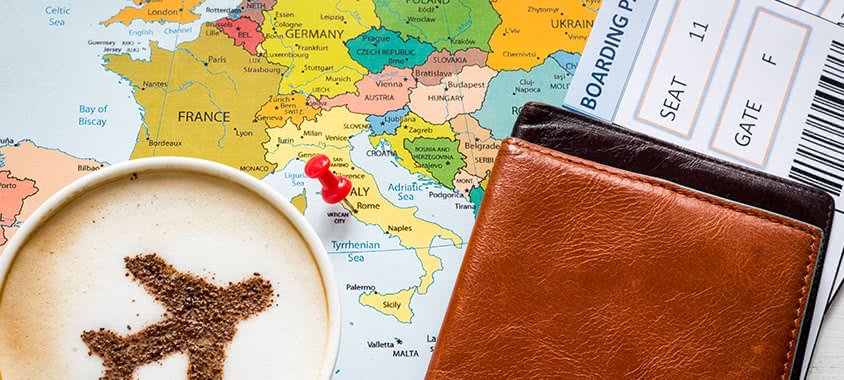 Reiseunterlagen auf einer Landkarte mit Kaffee Reiseunterlagen auf einer Landkarte mit Kaffee